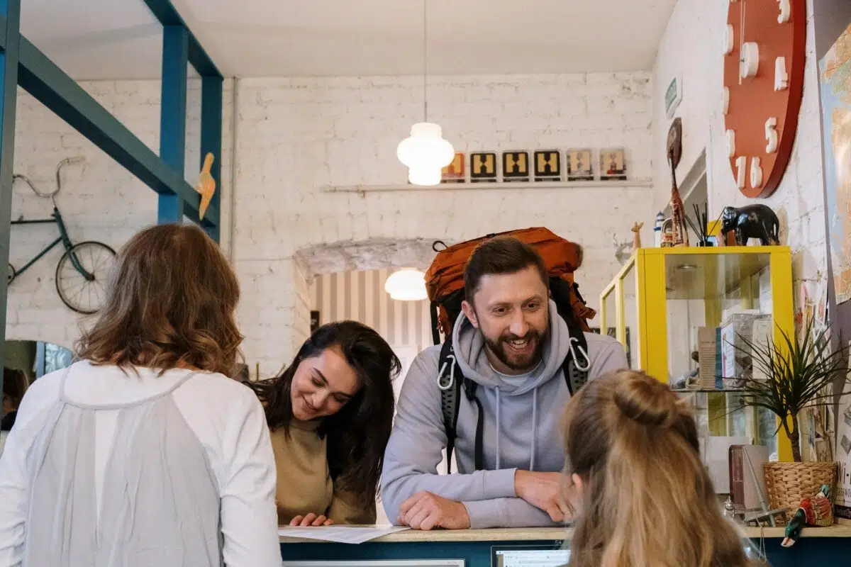 a happy customer speaks to a cashier at a front desk